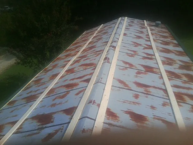 Rusted metal roof panels with new wood purlins before replacement — Storm Damage Roof Repair in New Zion by Roofing Brothers