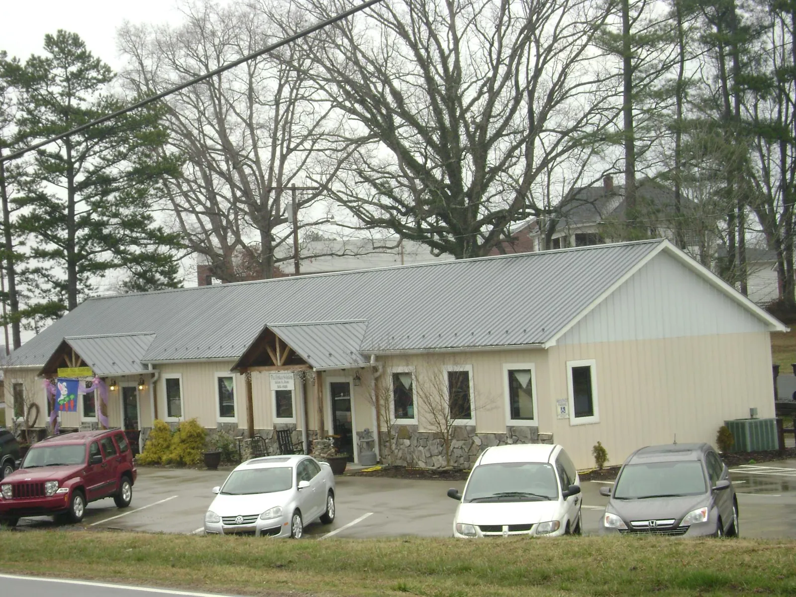 Gray metal roof with timber entry brackets on a small commercial building in New Zion