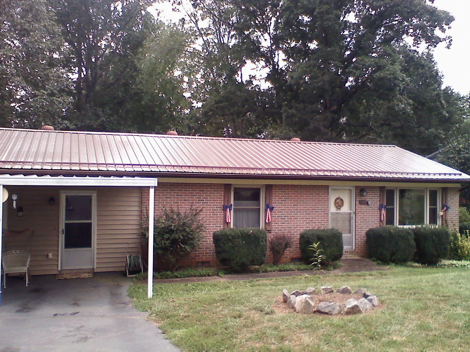 Bronze metal roof and carport on a brick ranch home — Roof Repair work by our crew in New Zion